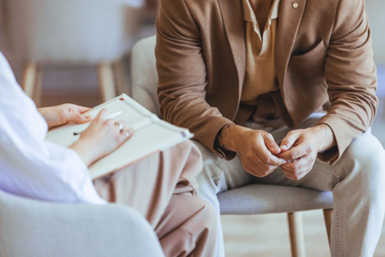 A therapist conducts a one-on-one counseling session with a male client in a bright office, reflecting the structured and skills-based environment of what is DBT therapy looks like.